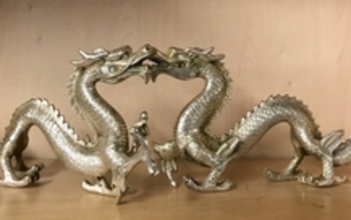 A pair of silver plated bronze figures of dragons, L. 33cm.