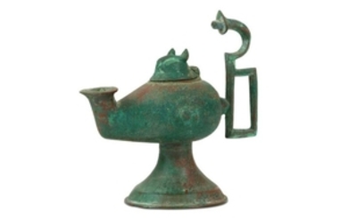 A FOOTED BRONZE OIL LAMP Iran, 10th - 12th century Of