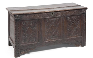 JACOBEAN LIFT-TOP CHEST In oak, with wrought iron hinges. Front carved with stylized foliage and geometric motifs. Capitals carved a...