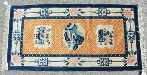 A CHINESE WOOL RUG with three motifs, orange ground