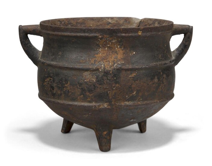 A Chinese iron cauldron form censer, 16th century, with two angular handles, the body decorated with two bow strings raised on three short feet, 14cm wide
