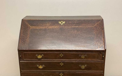 A George III oak bureau with four graduated drawers below...