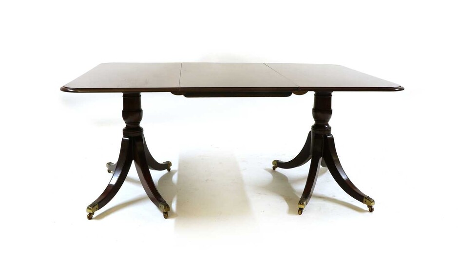 A George lll style mahogany twin pedestal dining table with one leaf