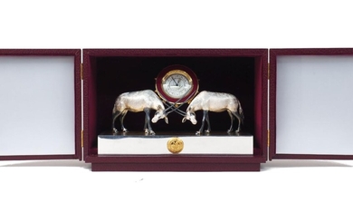 A Hilser for Grant MacDonald 9ct gold time piece with arabic numerals and cobichons, flanked by two oryx, on silver plated rectangular and gilt brushed base in presentation box, 28cm wide, 10cm deep Please note that Roseberys do not guarantee...