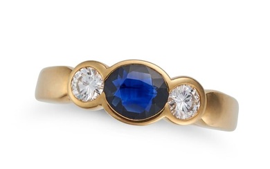 A SAPPHIRE AND DIAMOND THREE STONE RING set with an oval cut sapphire accented on each side by a