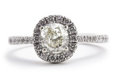 A diamond ring set with a fancy yellow diamond weighing app. 0.63 ct. encircled and flanked by numerous brilliant-cut white diamonds, mounted in 18k white gold.
