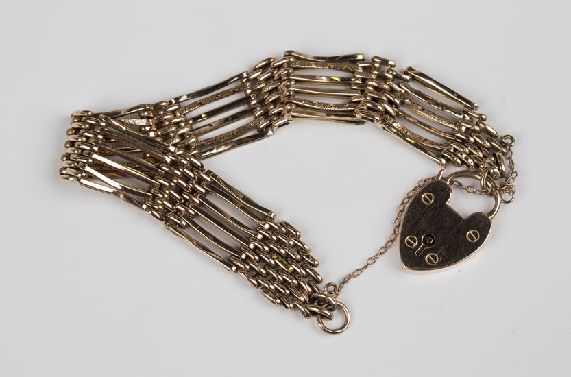 A gold bar and oval link gate bracelet on a gold heart shaped padlock clasp, detailed '9ct'