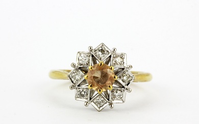 A hallmarked 18ct yellow and white gold ring set with an imperial topaz surrounded by diamonds, (P).