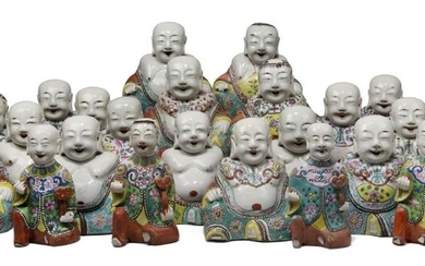 A large collection of Chinese porcelain famille rose figures, late Qing dynasty, with twenty-four figures of Budai painted wearing robes decorated with various designs, including lotus and chrysanthemum blossoms, bats and scrolling leafy vines, and...