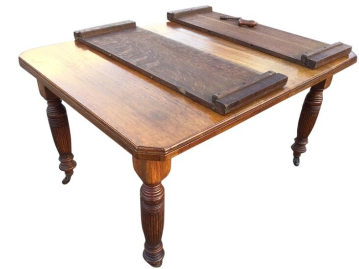 A late Victorian oak extending dining table, the rectangular...