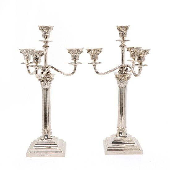 A pair of George III style silver candelabra, stems shaped as corinthian columns; swirled lighting arms. Copenhagen 1919. Weigh 2788 gr. H. 4.,5 cm. (2)