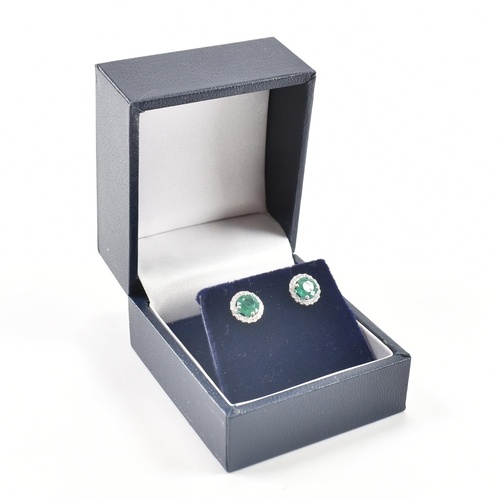A pair of hallmarked 9ct white gold emerald and diamond stud...
