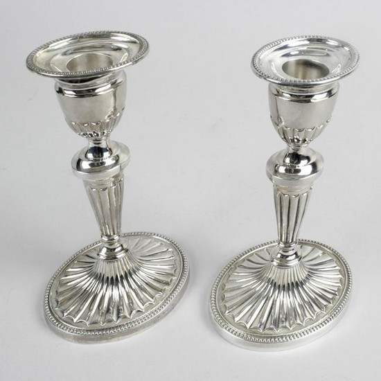 A pair of modern silver candlesticks, each with filled