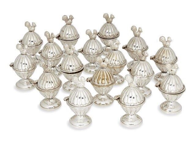 A set of sixteen novelty egg cups, each silver plated egg cup designed with hinged lid topped with chicken surmount, 10cm high (16) (VAT charged on hammer price)