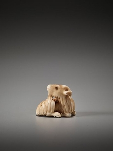 AN IVORY NETSUKE OF A RECUMBENT GOAT ATTRIBUTED TO…