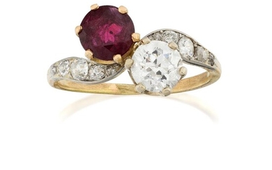 An Edwardian, diamond and ruby two stone ring, of crossover design, claw-set with a single old-brilliant-cut diamond weighing approximately 0.80 carats and circular-cut ruby to old-brilliant-cut diamond five stone graduated shoulders, c.1905...