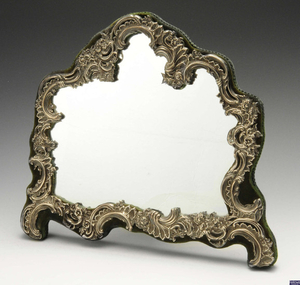 An Edwardian silver mounted easel back mirror of asymmetrical form.