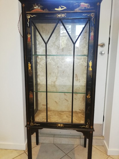 An English display cabinet of black painted wood decorated with chinoiserie designs in colour and gold. C. 1900. H. 148 cm. W. 58 cm. D. 32 cm.