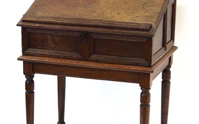 An oak clerk's desk, the sloped surface enclosing six drawers,...