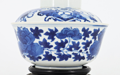 Ciotola in porcellana bianca e blu decorata con motivi floreali con base in legno, insieme a un coperchio non pertinente…