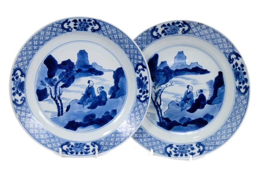 Good pair of Chinese blue and white porcelain dishes, each painted with two figures in a rocky landscape