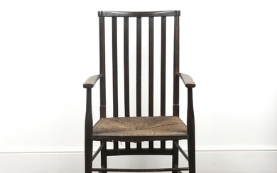 In the manner of Liberty and Co ebonised arm chair...