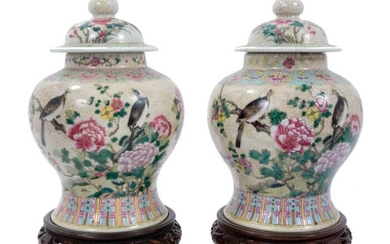 Pair of Chinese famille rose porcelain crackle-glazed jars and covers with carved hardwood stands, approximately 26cm excluding stands.