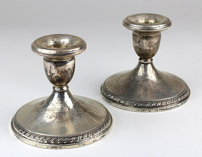Pair of low table candlesticks, sterling silver, USA, Cartier M. 20th century, each foot with stylized leaf band in relief, stamped on the base: Cartier, sterling... 2593 and signet, each filled, height 8.2 cm, signs of age and wear, 2486 - 0024