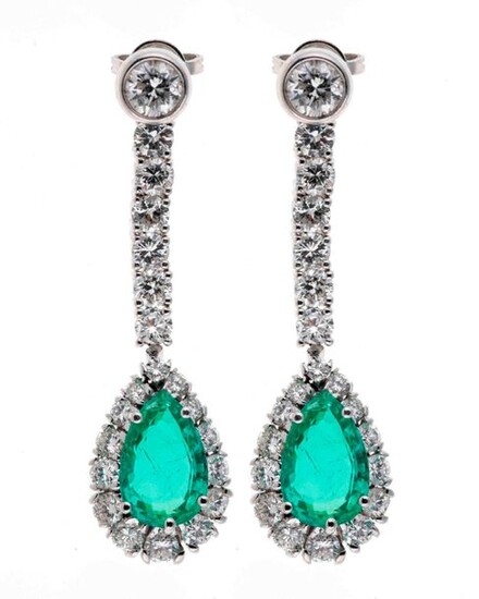 Pair of white gold earrings adorned with a diamond holding...