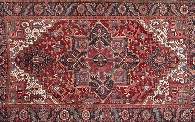 Persian HERIZ carpet, hand-knotted with high quality wool Northwest of Iran. Design based on a central poly-lobed medallion on a background completely covered with schematic plant samples. Marked corners. Red background and ivory decoration