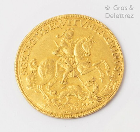 Prophylactic amulet in yellow gold representing on the obverse Saint George on horseback slaying the dragon underlined with the phrase "S GEORGIUS EQUITUM PATRONUS" or "Saint George, patron saint of riders". On the reverse: two figures in a sailing...