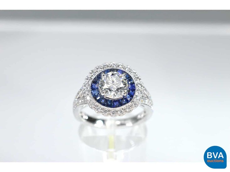 White gold ring with a large diamond surrounded by sapphires and brilliant cut diamonds.