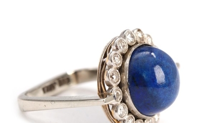 Lapis lazuli and diamond ring set with cabochon-cut lapis lazuli encircled by numerous old-cut diamonds, mounted in 14k white gold. Size app. 50.