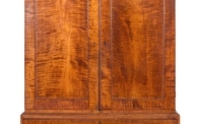 CHIPPENDALE TWO-PART LINEN PRESS In strong tiger maple. Upper case with molded top and two closed-face paneled doors enclosing three...