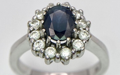 A 14K White Gold Sapphire and Diamond Ring. Oval...