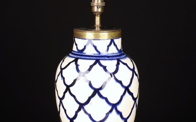 A Ceramic Table Lamp. The ovoid body decorated with a flo blue glazed scalloped scale design, fitte