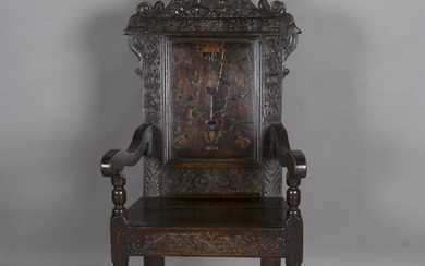 A Charles II Yorkshire oak wainscot armchair, the shaped top rail carved with leaves, fruit and scro
