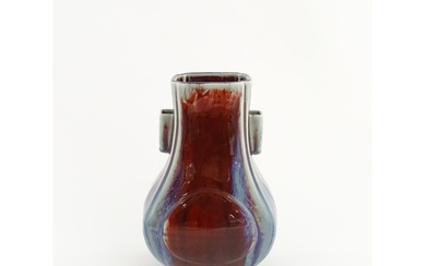 A Chinese sang de boeuf vase with twin handles and roundel d...