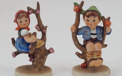 A Hummel figurine, 'Apple Tree Boy', 20th century, model no 142 3/0 on base, 10cm high; together with a Hummel figurine of a girl seated in a flowering tree, model no. 141 3/0 on base, 10cm high (2)