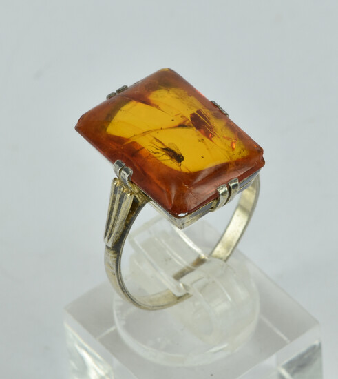 A STERLING SILVER AND AMBER RING
