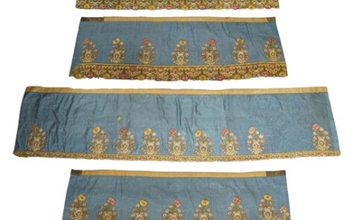 A group of five lambrequins, featuring English 17th century embroidered wreaths of flowers tied with ribbons, above a frieze of ribbons and flowers, assembled on a later blue silk moire ground with ochre lining to the verso, dimensions...