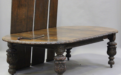 A late Victorian Carolean Revival carved oak extending dining table, the top with five extra leaves
