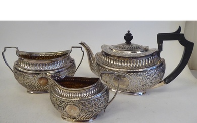A late Victorian silver three piece tea set of oval form wit...