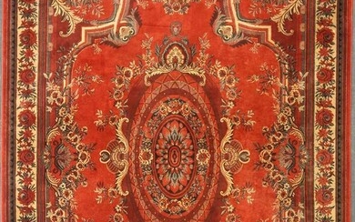 A machine woven red ground rug with repeating floral border, 342 x 250cm
