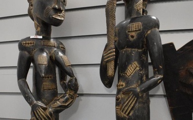 A pair of African carved stone figures, one female with suckling baby and the other depicting male.