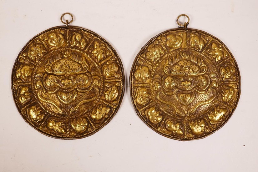 A pair of Chinese brass and gadrooned metal plaques with rep...
