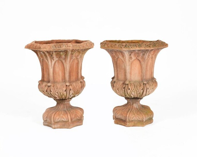 A pair of terracotta garden urns in the manner of Royal Doulton, octagonal section, each cast with arch panels to the body, the foot cast with flowerhead motif, unsigned, 50cm. high, (2) Provenance The collection of Pam and Mark Taylor.