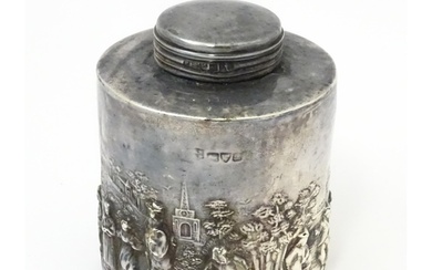 A silver tea caddy depicting a village scene with buildings ...