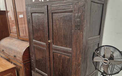 AN ANTIQUE OAK WARDROBE, THE DOORS WITH TWO PANELS AND ENCLOSING HANGING SPACE. W 92 x D 47 x H