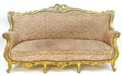 An Italian giltwood three seat sofa with a carved and